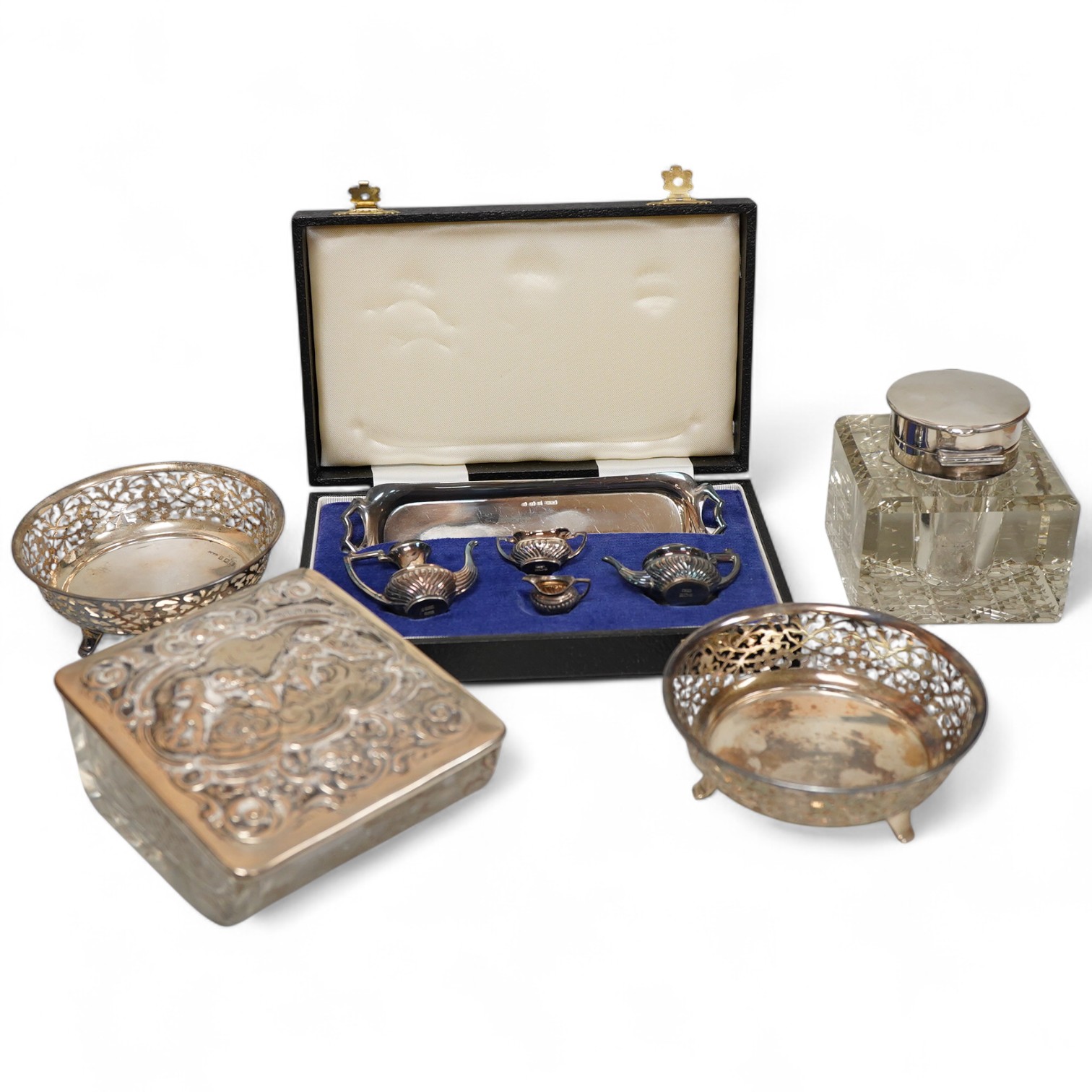 Small silver including a pair of George V pierced silver bonbon dishes, Birmingham, 1915, diameter 97mm, an Edwardian silver mounted glass inkwell, a cased modern silver miniature four piece tea set and tray and a German